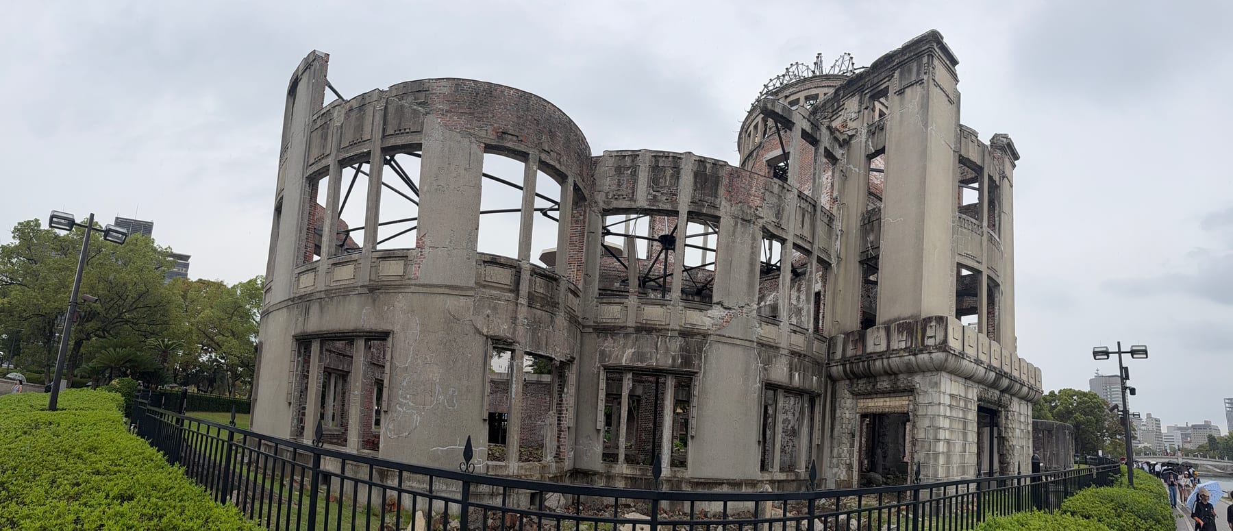 The skeletal dome of a ruined building stands behind a railing, its bare framework open to the sky.