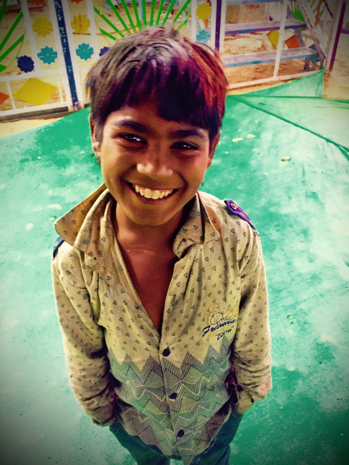 A young boy turns toward the camera in soft daylight.