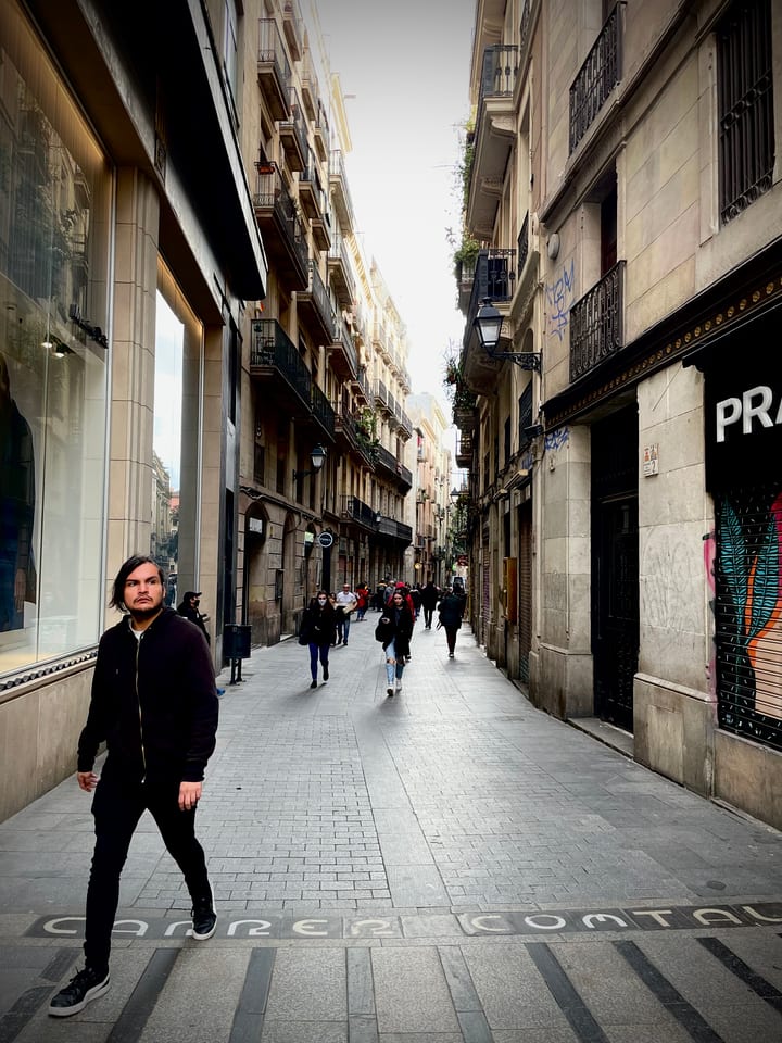 A narrow stone street in the old quarter receding into shadow, a single small figure walking in the distance.